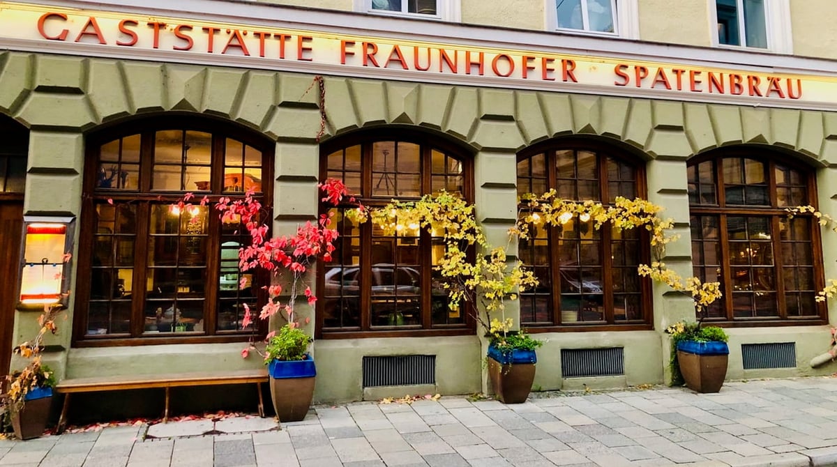 Fassade der Gaststätte Fraunhofer in der Fraunhoferstraße mit Rundbogenfenstern und herbstlich gefärbtem Wein