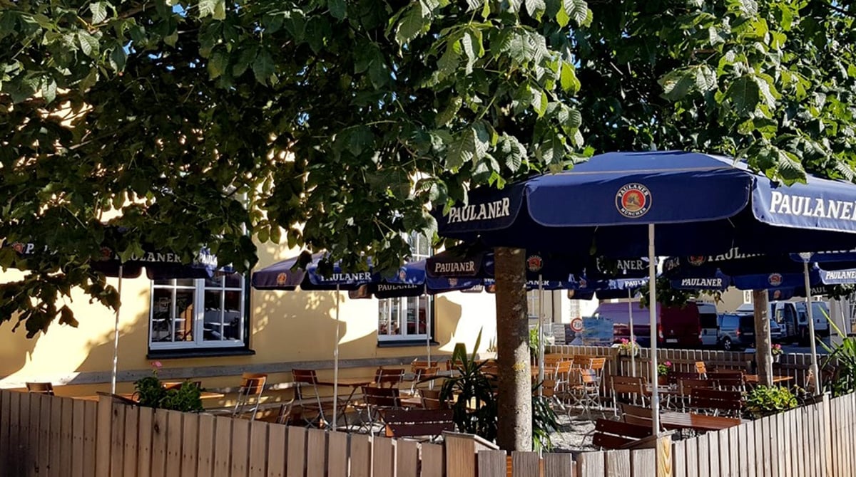 Terrasse der Gaststätte Großmarkthalle unter einem großen Baum mit Sonnenschirmen