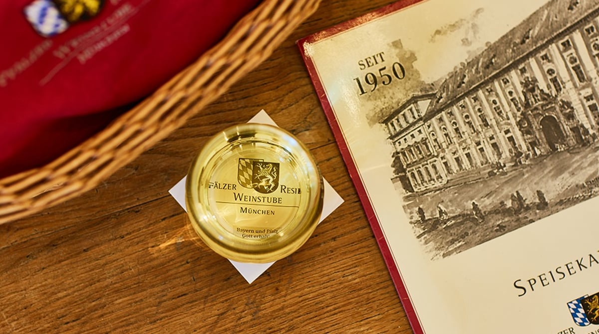 Speisekarte der Pfälzer Residenz Weinstube mit Ansicht der Residenz auf einem Holztisch