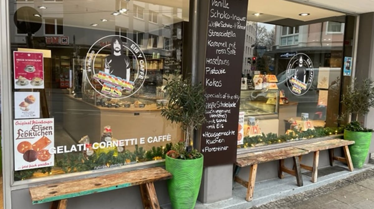 Außenansicht der Jessas-Filiale in der Müllerstraße mit Schaufenster, Tafel und Holzbänken