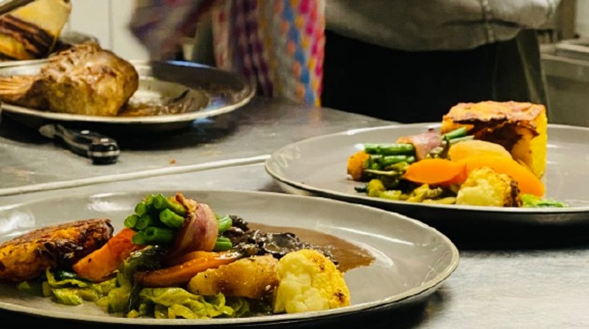 Angerichtete Hauptgerichte mit Fleisch und Gemüse am Küchenpass