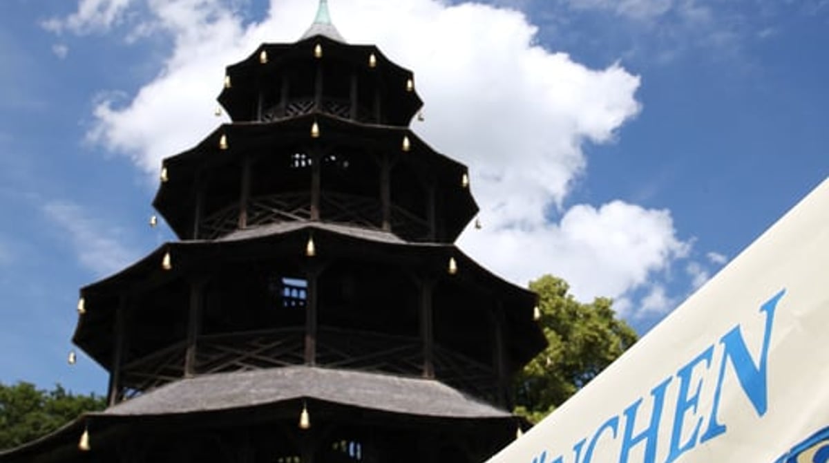 Der Chinesische Turm mit Hofbräu-Sonnenschirmen vor blauem Himmel