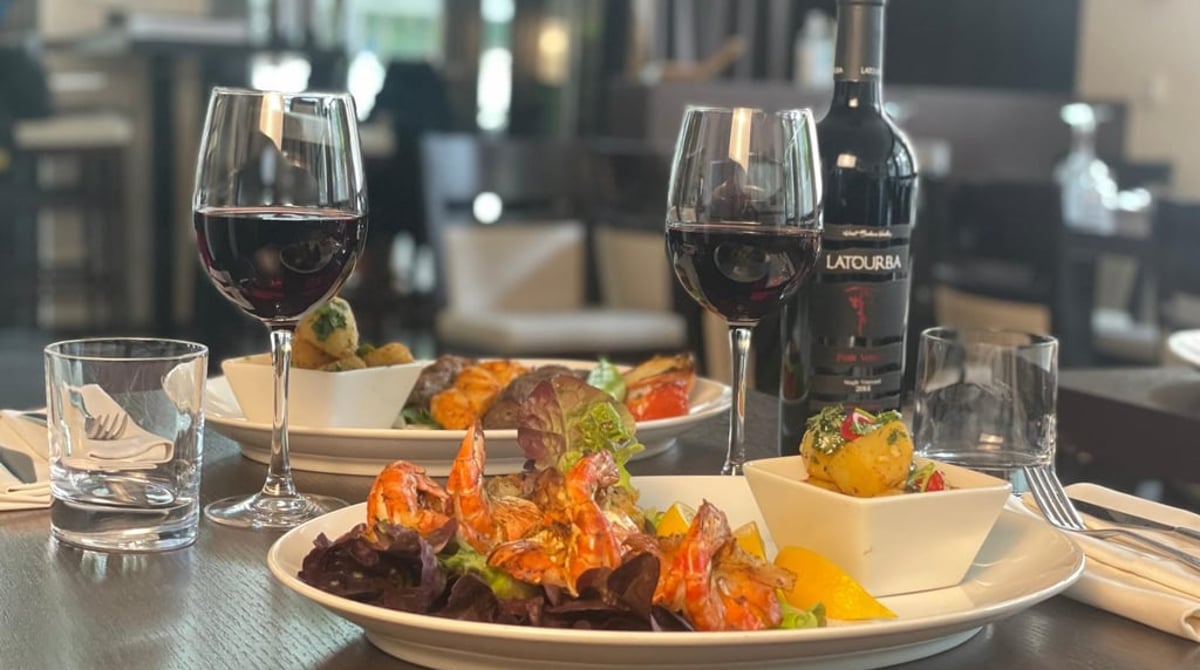 Gegrillte Scampi auf Salat, dazu ein Glas Rotwein im Baalbek