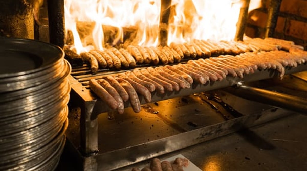 Rostbratwürstl auf dem Rost über dem offenen Buchenholzfeuer im Bratwurst Glöckl