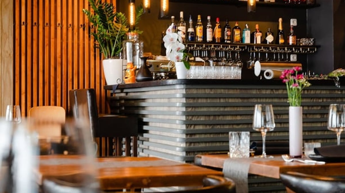 Bar mit Flaschenregal und Pendelleuchten im Zento