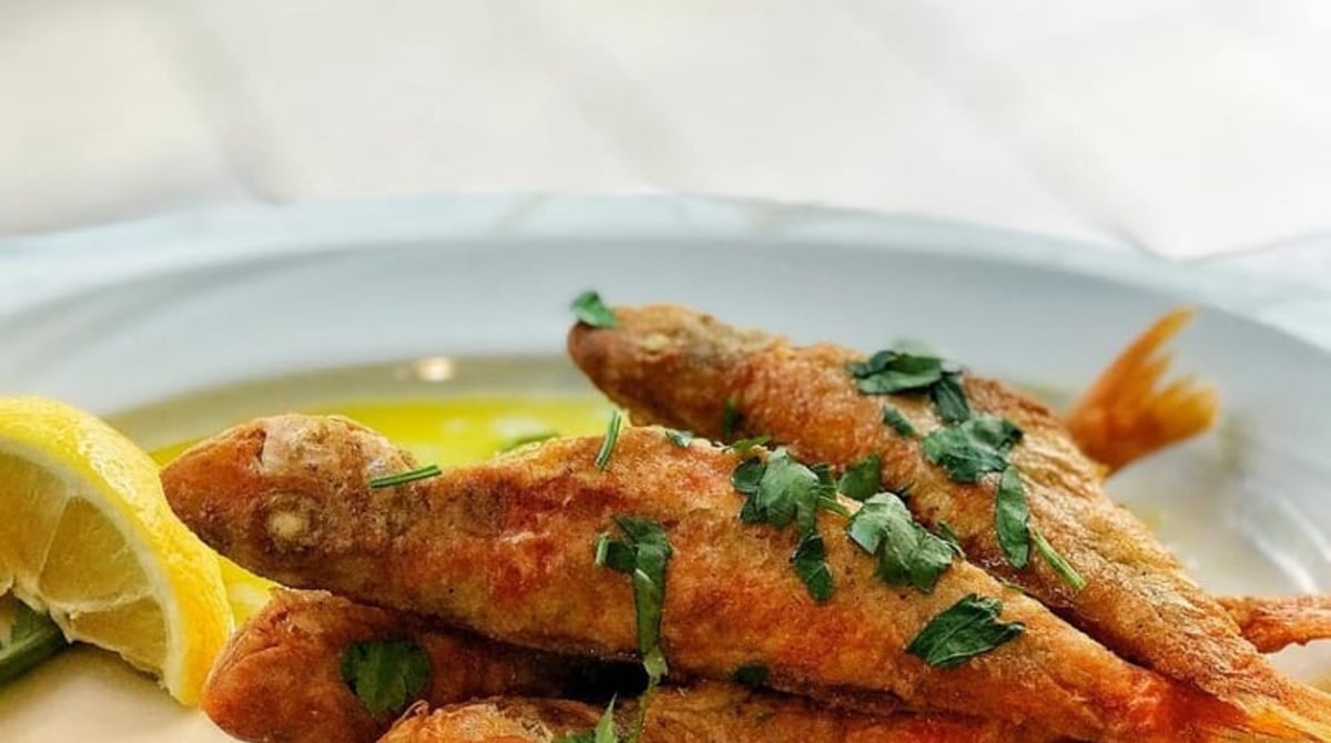 Gebratene Rotbarben mit Zitrone auf einem Teller im Restaurant Piatsa in München-Schwabing