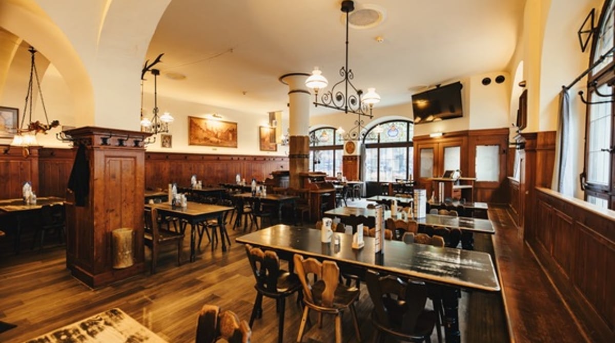 Gastraum „Die Schwemme" im Weisses Bräuhaus im Tal in München mit langen Holztafeln