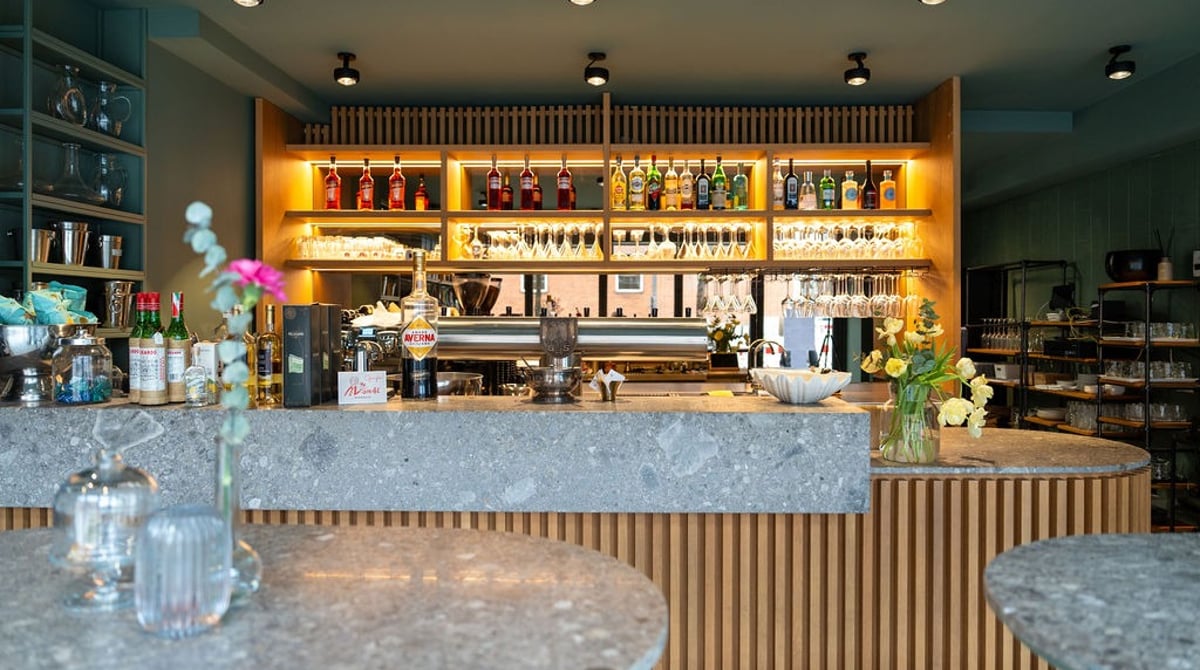 Bar mit Holzlamellen-Front und beleuchtetem Flaschenregal
