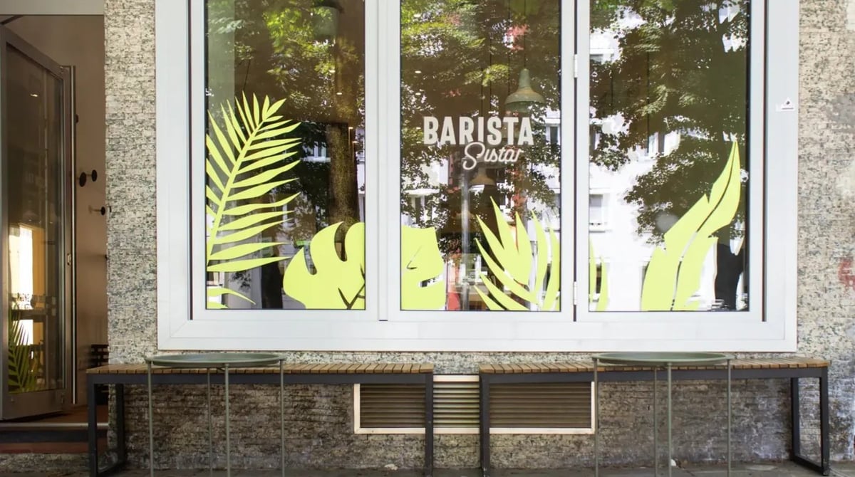 Schaufenster des Barista Sistar an der Deisenhofener Straße mit Schriftzug und gelben Palmenblättern auf dem Glas