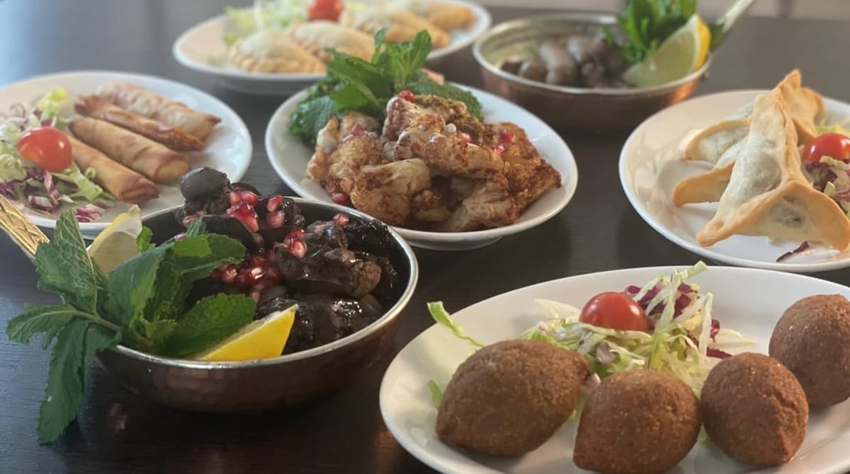 Tisch mit libanesischen Mezze-Schalen, Falafel und Hähnchenspießen im Restaurant Baalbek in München