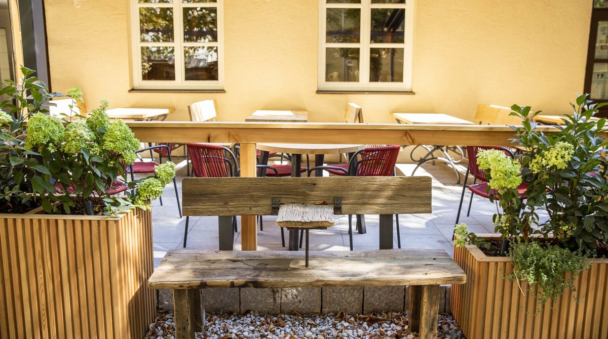 Terrasse mit Bank und Pflanzkübeln vor dem Wirtshaus