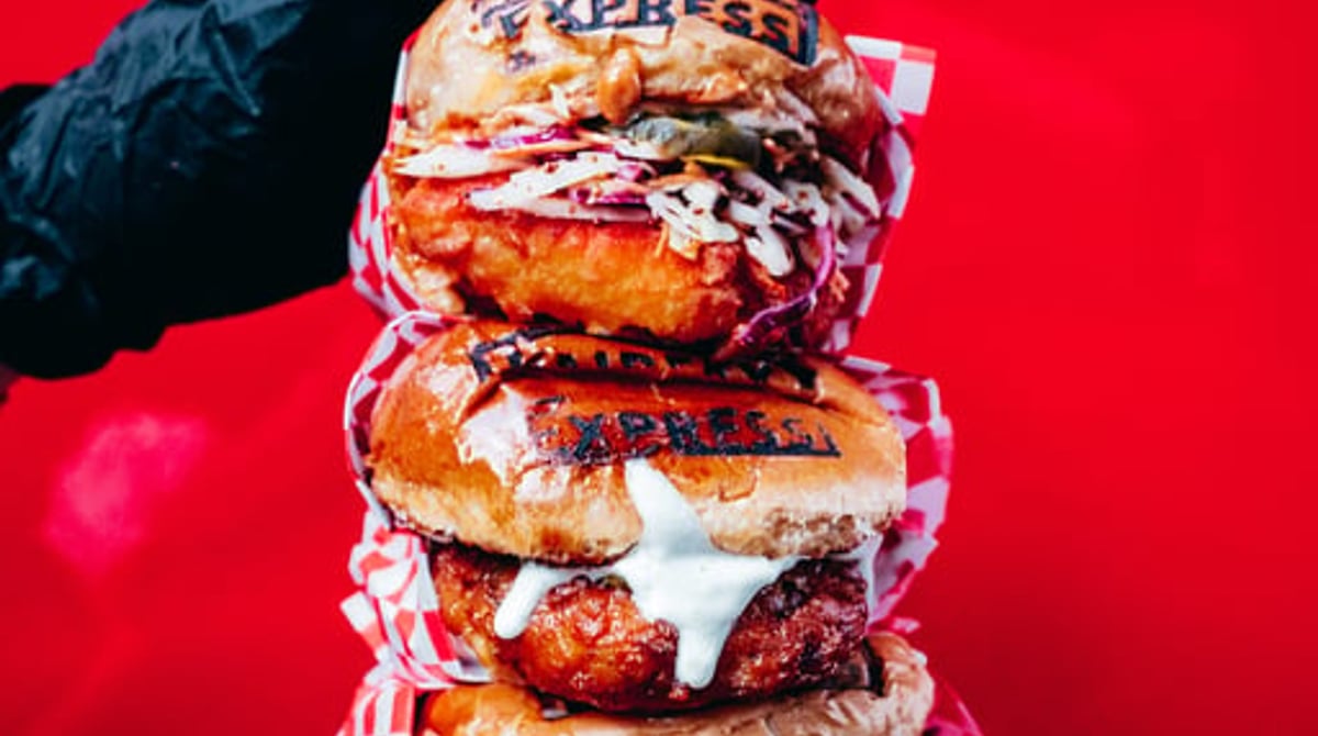 Gestapelte Chicken Sandwiches von Fairfax Express vor rotem Hintergrund