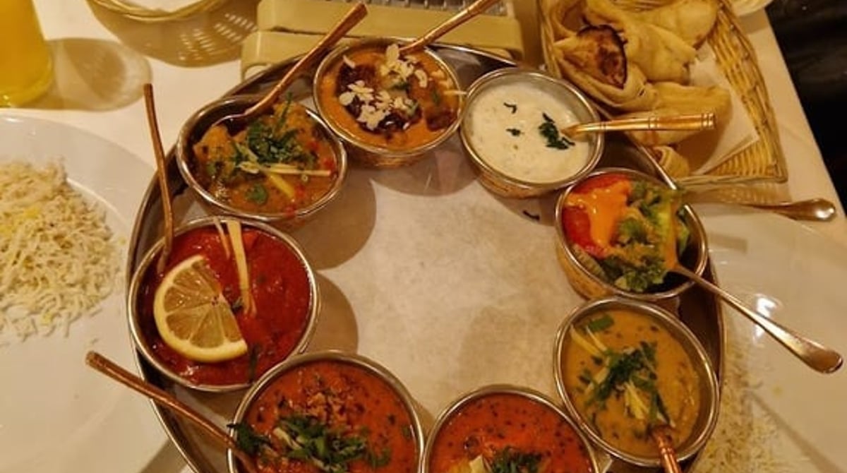 Thali-Platte mit Currys in kleinen Kupferschalen, Reis und Papadam