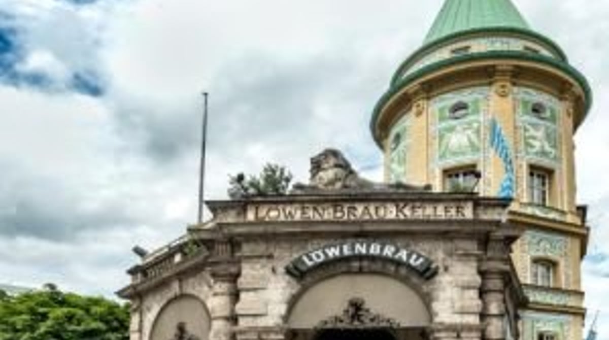 Fassade des Löwenbräukellers am Stiglmaierplatz in München mit Turm und grünem Dach