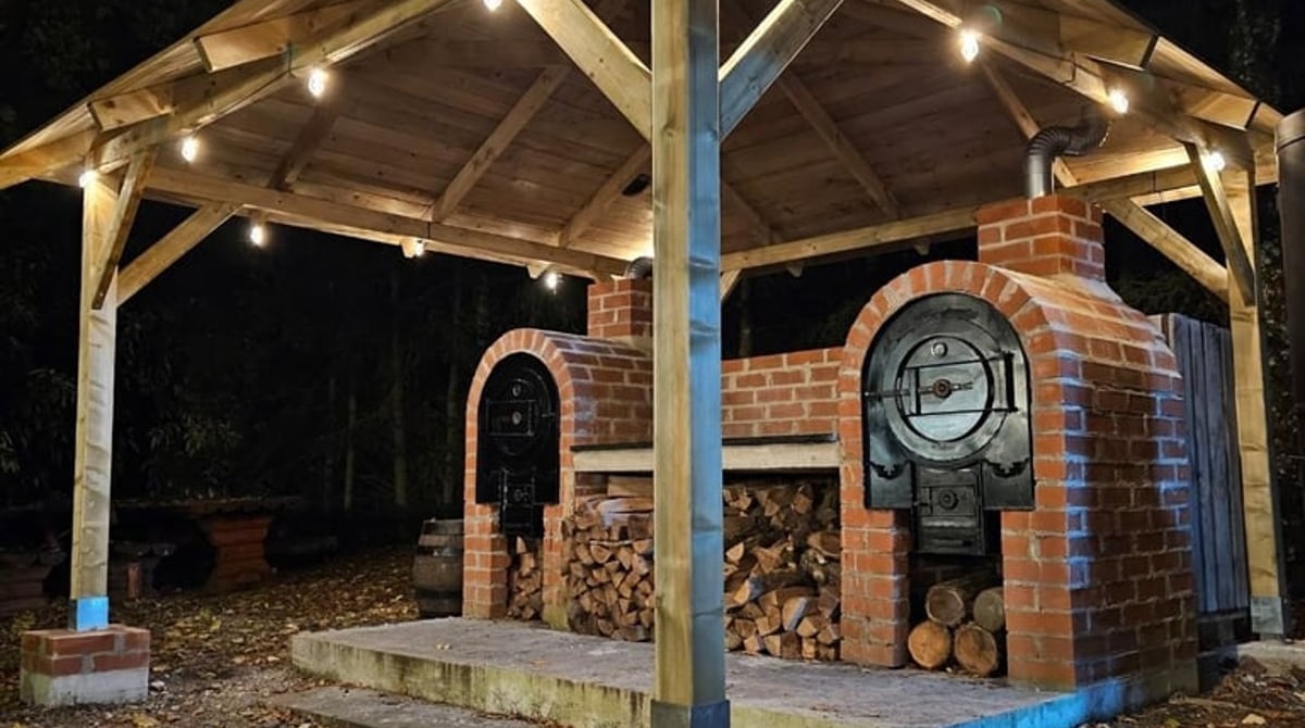 Überdachter Pavillon mit gemauertem Holzofen und Lichterkette am Gasthaus Maxhof