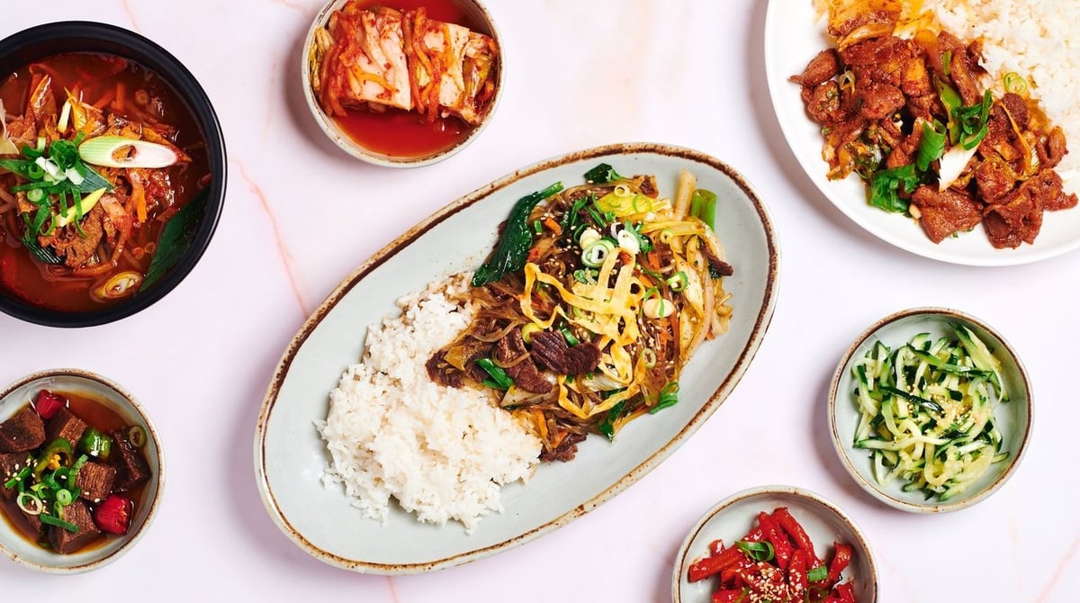 Koreanische Gerichte auf einem Tisch im Zum Koreaner: Japchae, Suppe, Fleisch und Beilagen