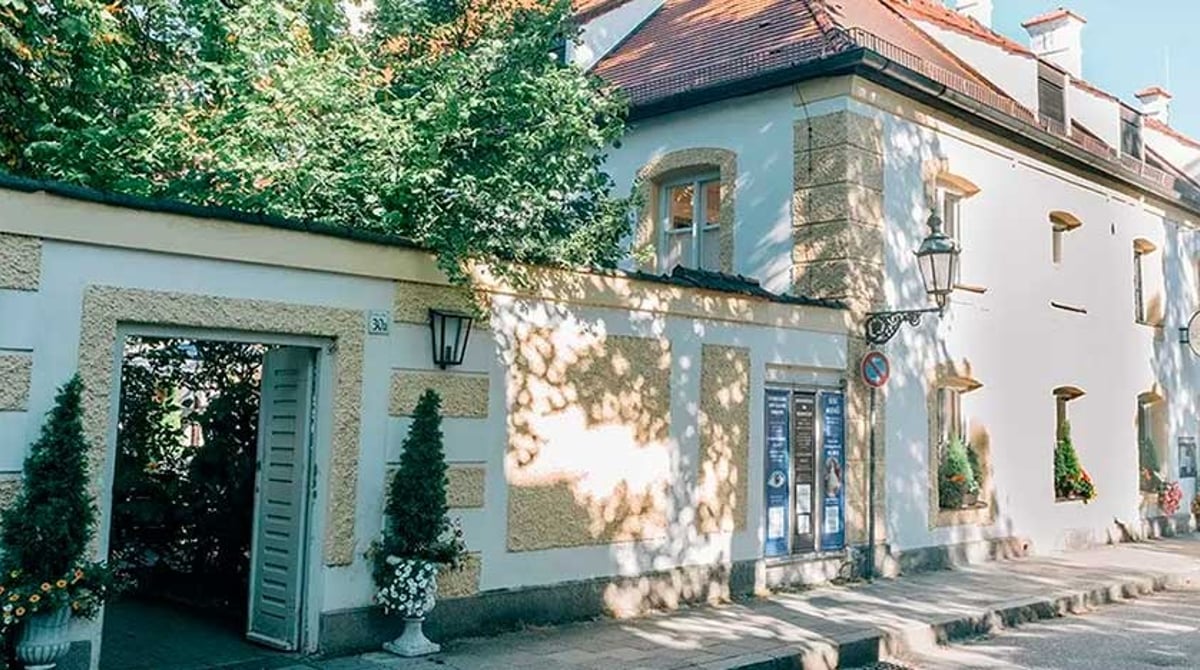 Eingang zum Biergarten der Schlosswirtschaft Schwaige in der weißen Mauer am Schloss Nymphenburg