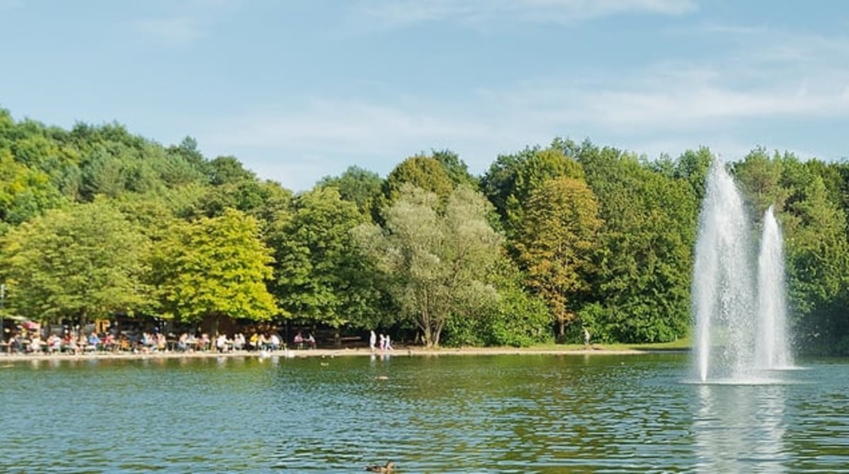 Blick über den Ostparksee mit zwei Fontänen, am Ufer der Biergarten des Michaeligartens