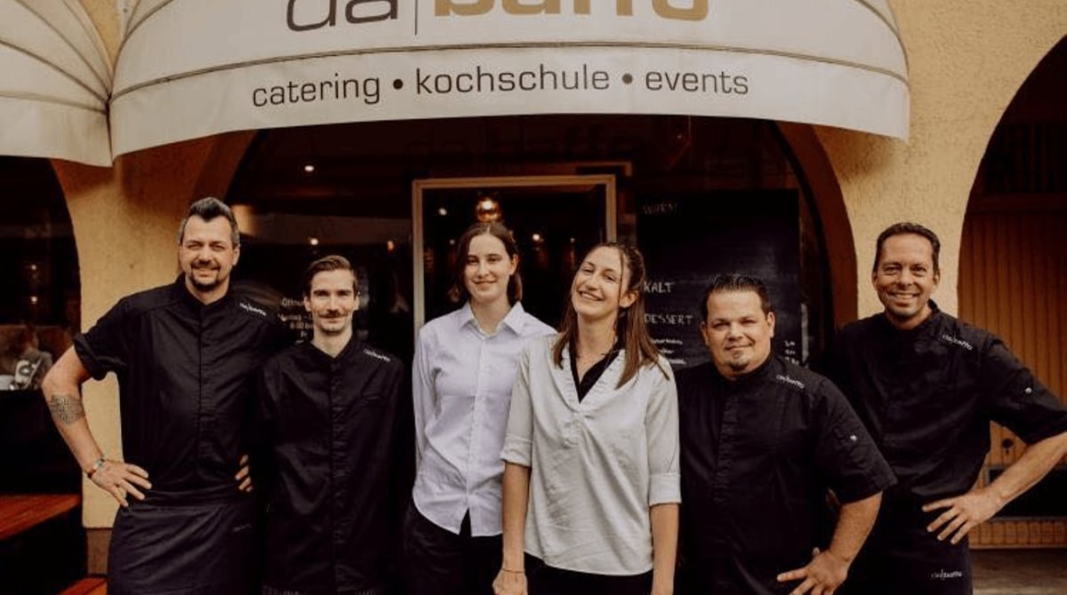 Das Team des Da Baffo vor dem Eingang mit dem Schriftzug catering, kochschule, events
