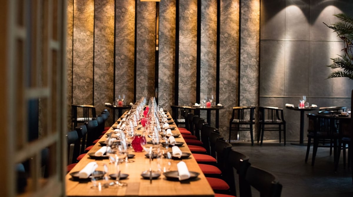 Lange gedeckte Tafel vor Wandpaneelen im Restaurant Azuki