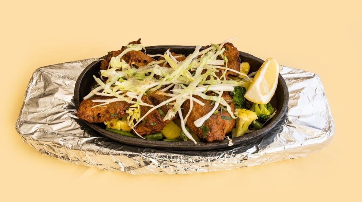 Lammtikka mit Ingwerstreifen und Zitrone auf der heißen Platte