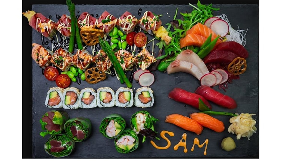 Die Platte Sushi & Friends mit Sashimi, Maki und Gemüse, dazu der SAM-Schriftzug