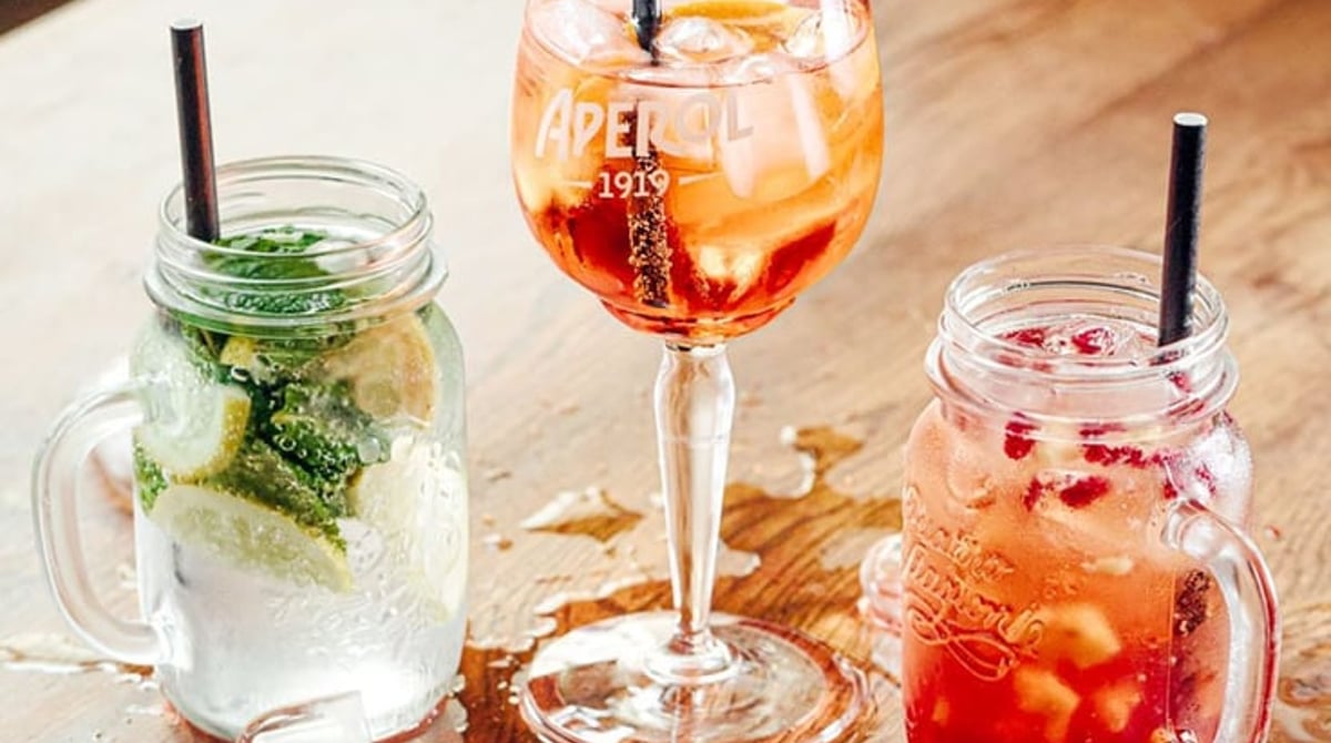 Hausgemachte Limonaden und Aperol Spritz auf einem Holztisch
