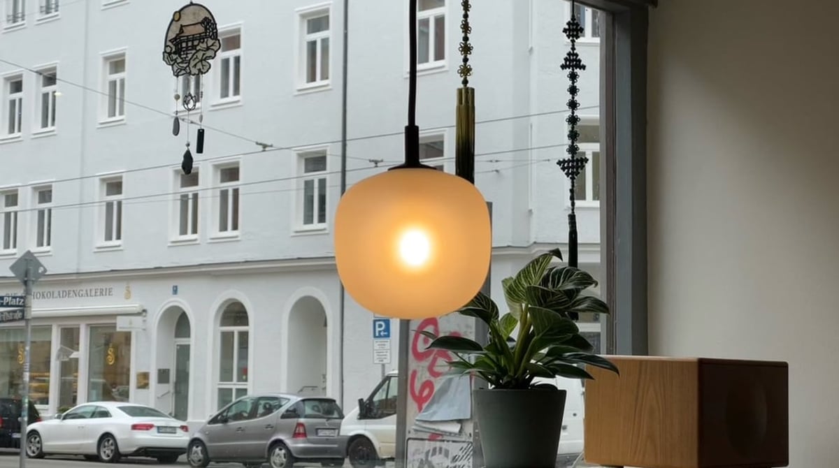Fensterplatz mit Hängeleuchte und Pflanze im Gastraum des arisu