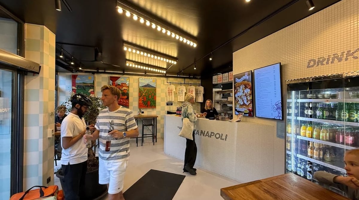 Verkaufsraum mit weißem Mosaiktresen, Getränkekühlschrank und Menütafeln eines Forza-Napoli-Standorts