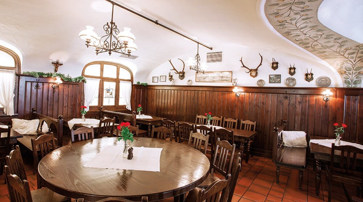 Gastraum mit rundem Tisch, Geweihen und Holzvertäfelung im Zum Dürnbräu