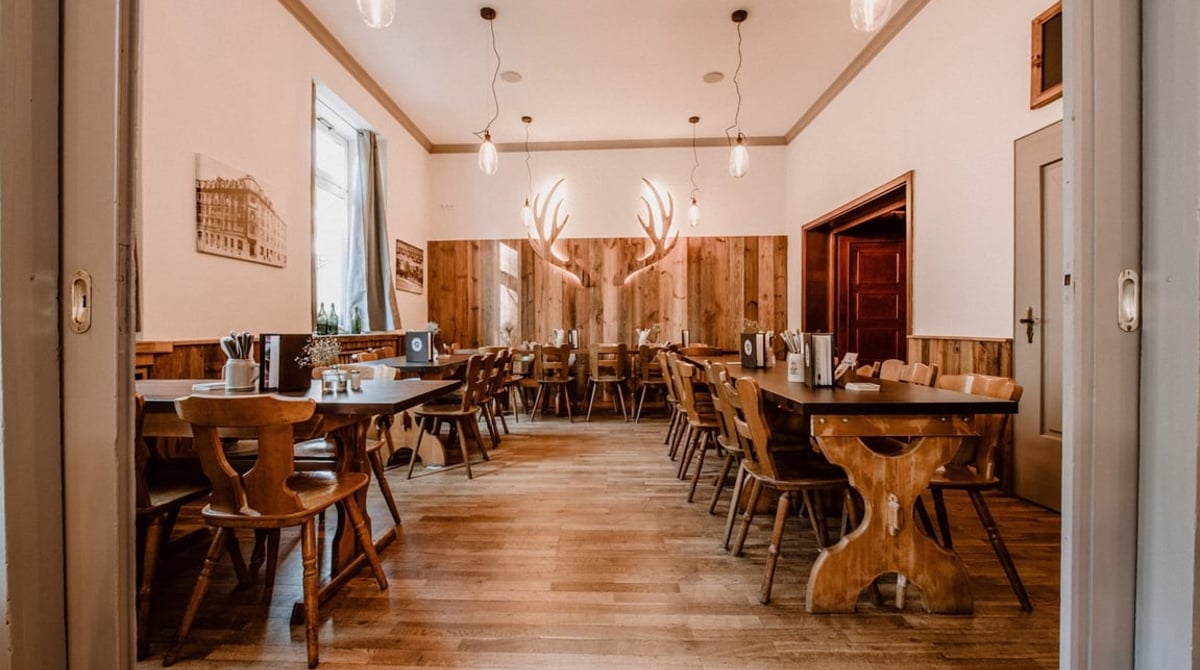 Holzgetäfelter Gastraum mit Geweihleuchtern und Holztischen im Wirtshaus Hohenwart