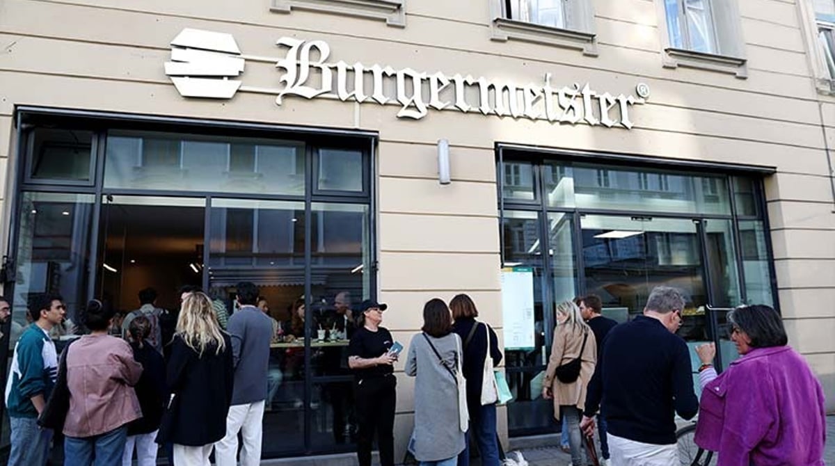 Laden von Burgermeister in der Türkenstraße mit großer Fensterfront und Gästen davor