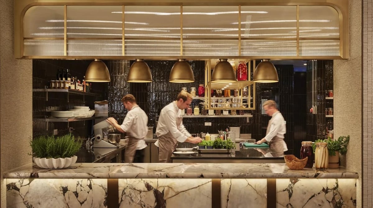 Offene Küche der Brasserie Cuvilliés, Köche arbeiten hinter einem Marmortresen