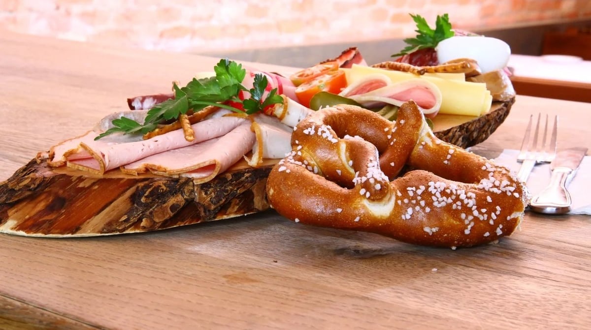 Brotzeitbrett mit Schinken, Käse und Breze