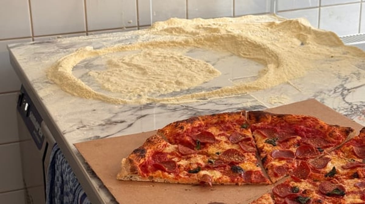 Pizzen im Neo-New-York-Style auf einer Arbeitsfläche vor gefliester Wand im Slice Shop