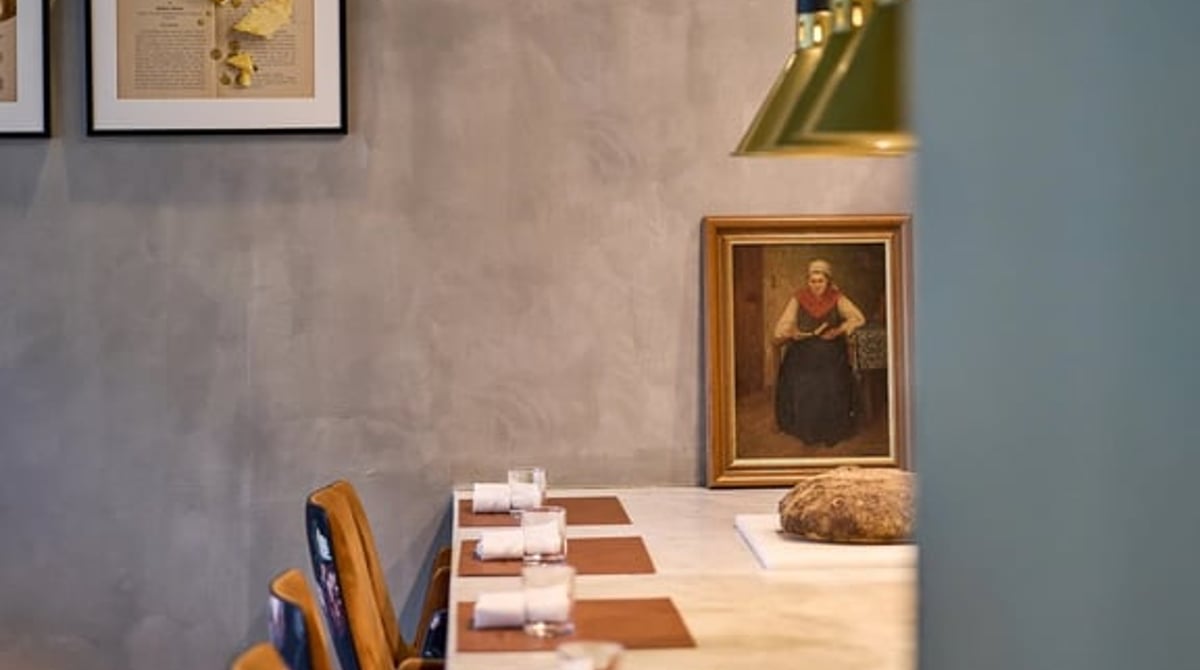 Blick entlang der Theke im Tschecherl mit Pendelleuchten und einem Gemälde an der Wand