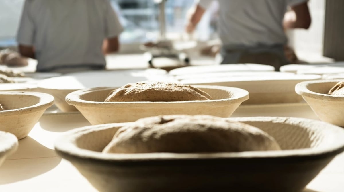 Teiglinge in Gärkörben auf der Arbeitsfläche der Backstube