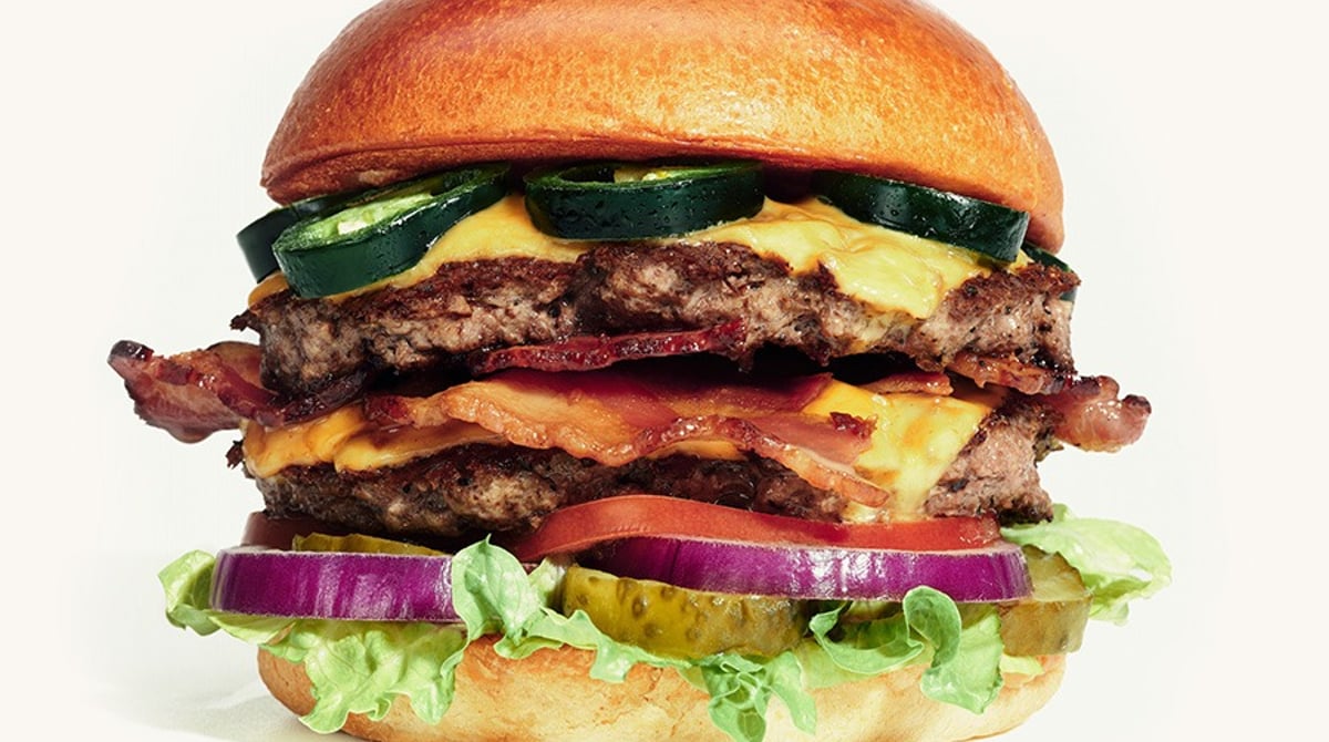 Burger Meister aller Klassen mit zwei Patties, Käse, Bacon, Jalapeños und Salat