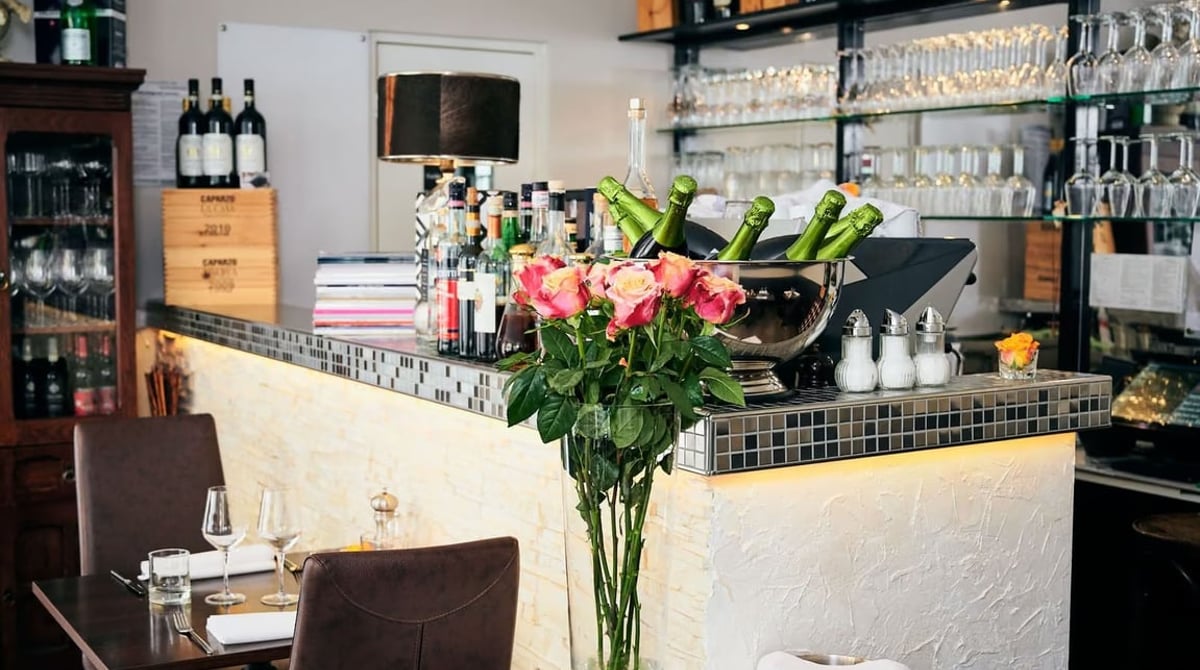Die Bar des Cupido mit Mosaiktheke, Flaschenregal und Rosen