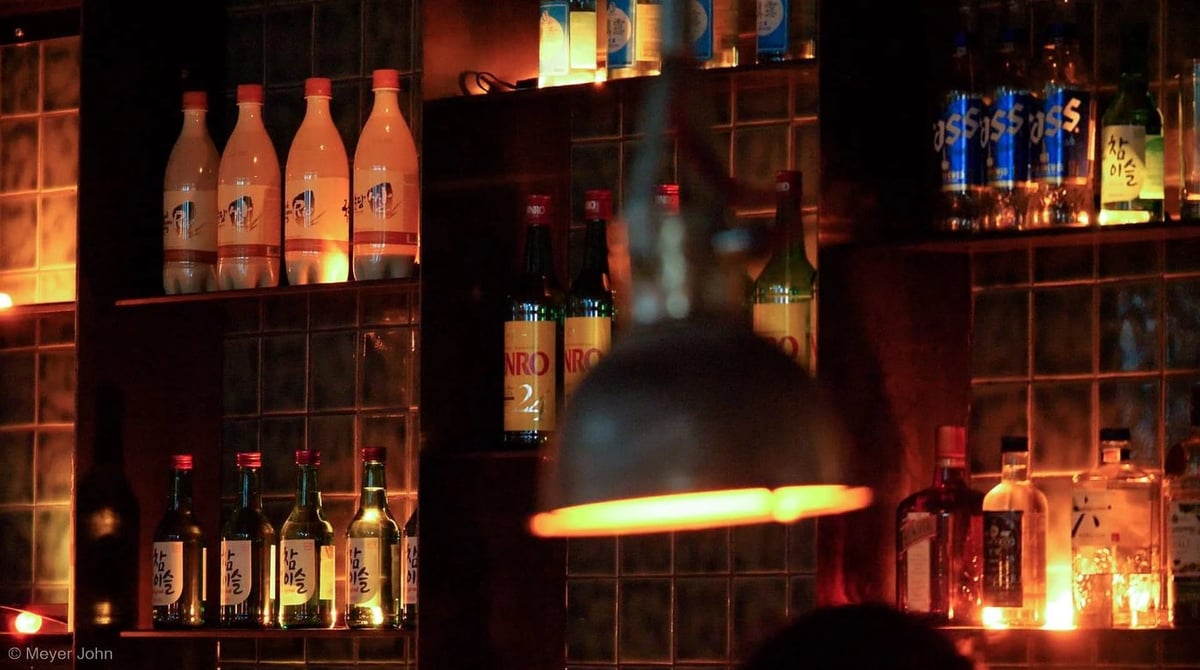 Regal mit Soju- und Makgeolli-Flaschen im 89 Anju