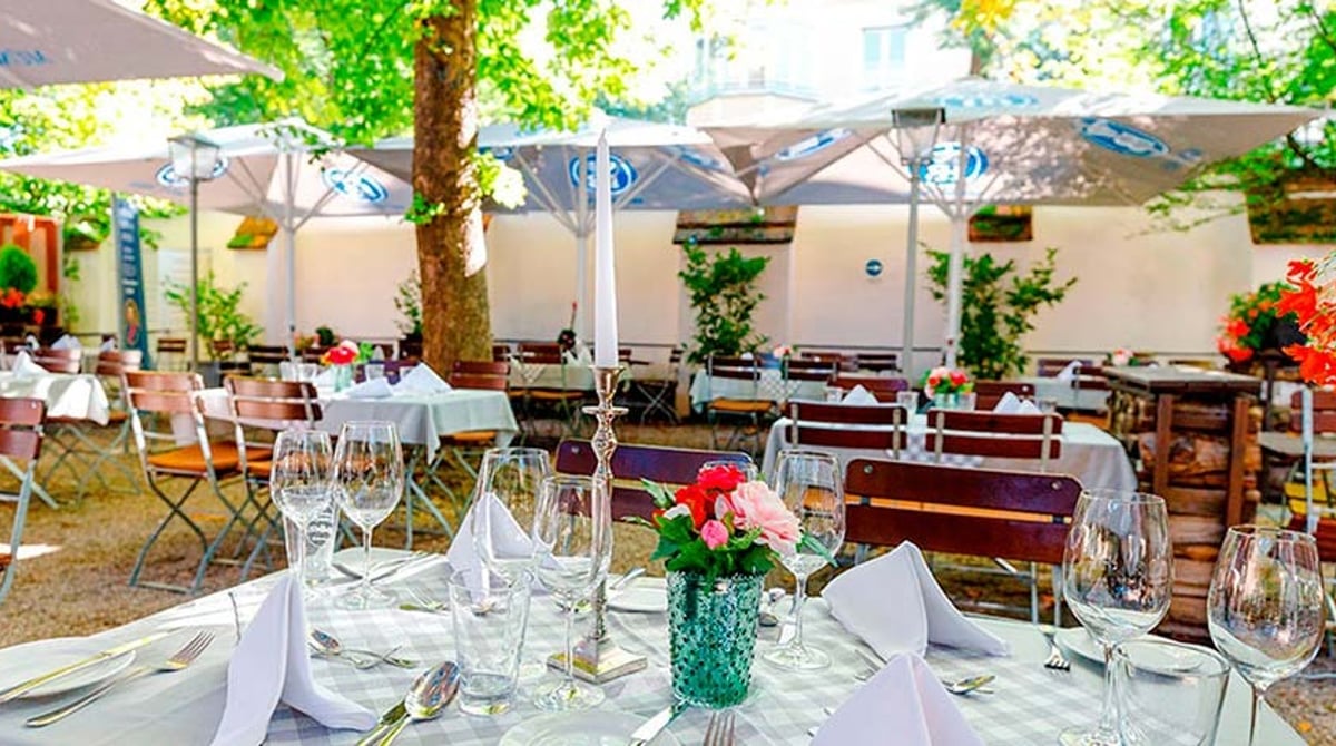 Eingedeckte Tische im Schatten der Kastanien im Schlossbiergarten
