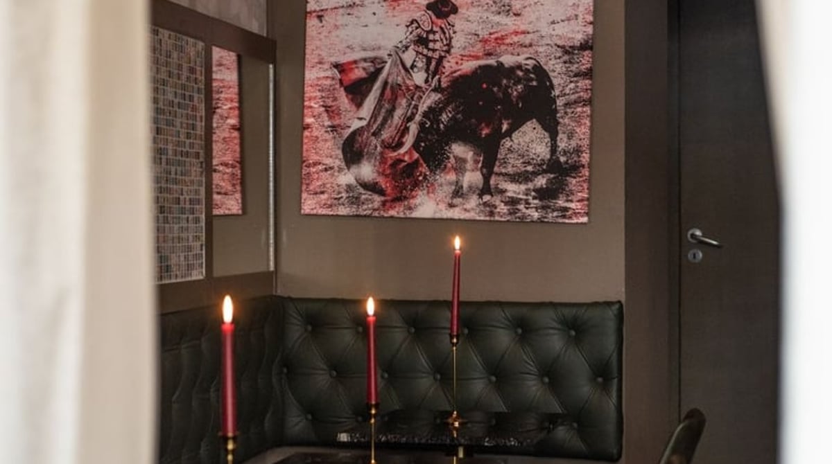 Sitzbank mit Kerzen und einem Stierkampf-Bild im Mio