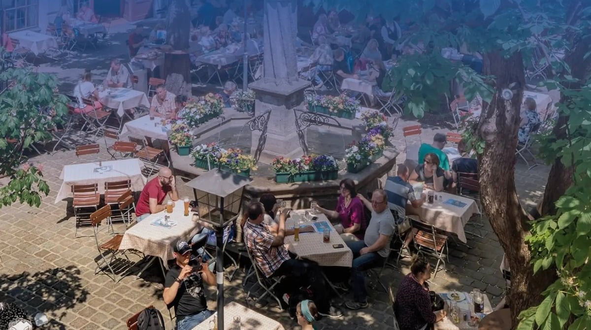Wirtsgarten im Innenhof des Hofbräuhauses mit Brunnen, Blumenschmuck und Kastanienbäumen