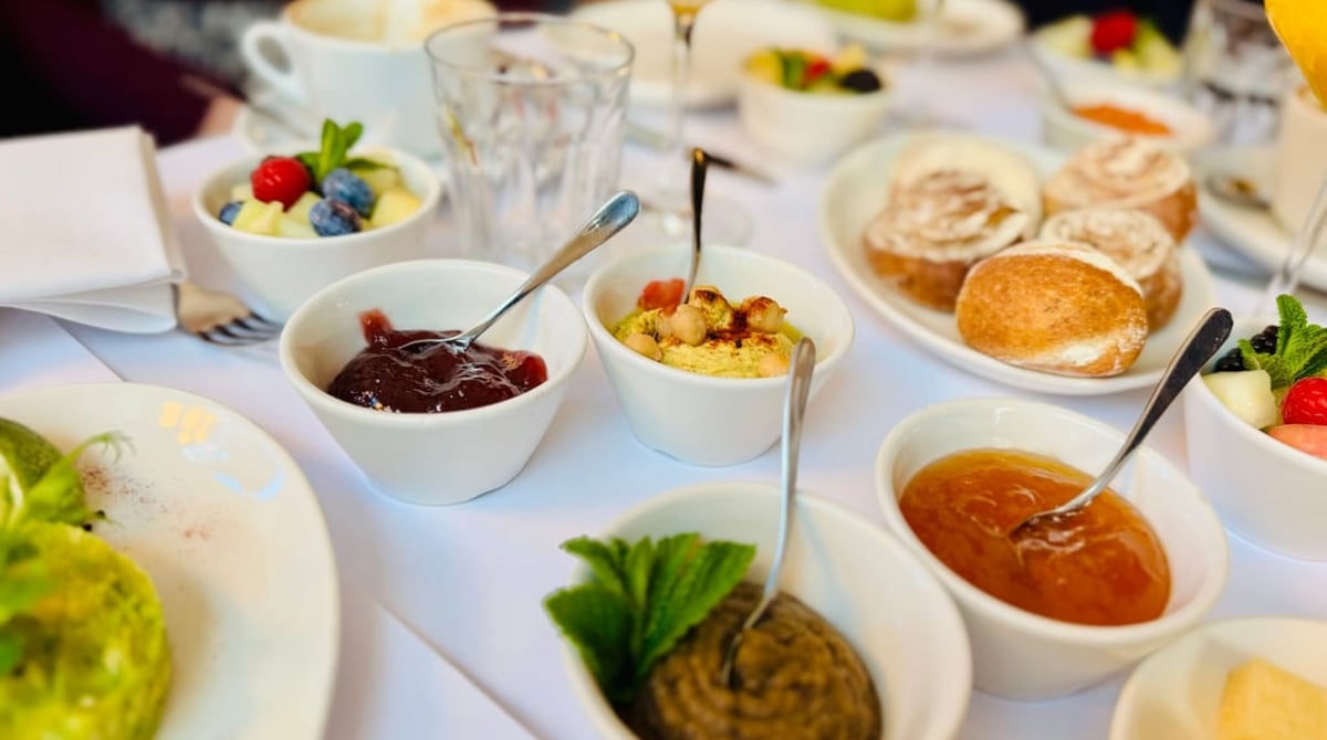 Frühstückstisch im Brenner mit Brötchen, Marmeladen, Aufstrichen und Obstsalat
