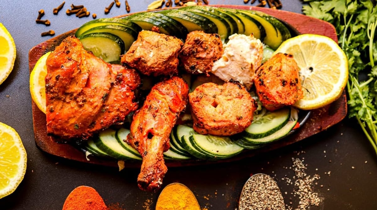 Tandoori-Platte mit Hähnchen, Kebab und Gurkenscheiben im Indian Mango