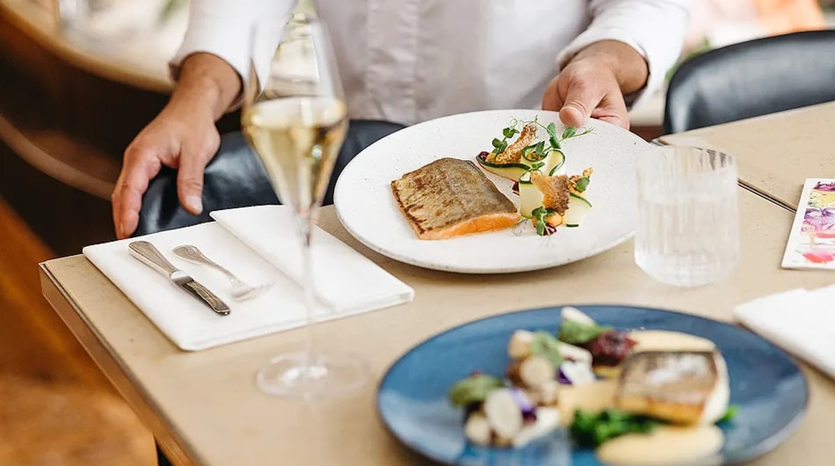 Servierter Fischteller mit Gemüse und einem Glas Champagner am Tisch