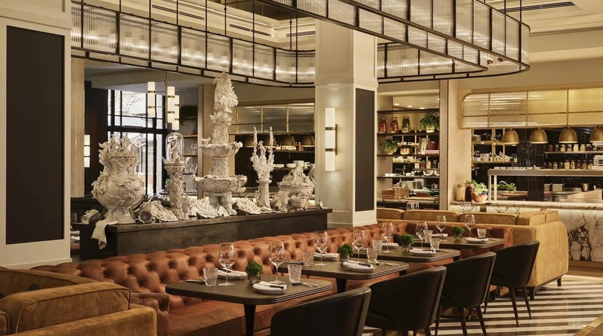 Gastraum der Brasserie Cuvilliés mit Lederbänken, dunklen Holztischen und einer weißen Porzellanskulptur im Hintergrund