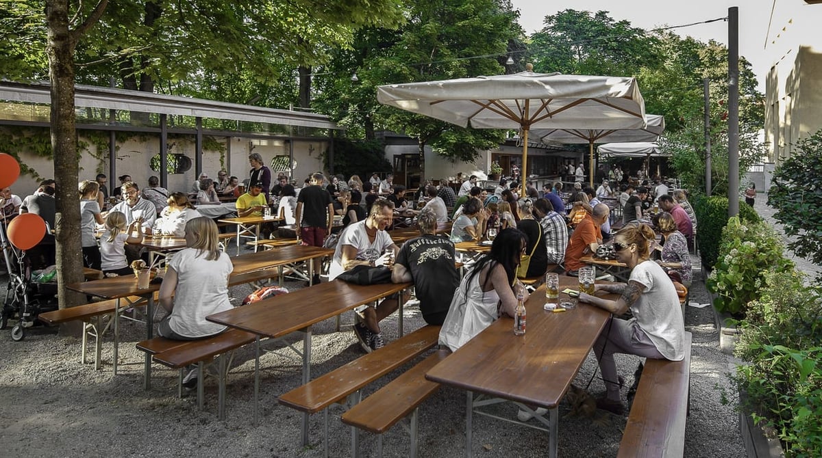 Vollbesetzter Biergarten am Muffatwerk an der Isar