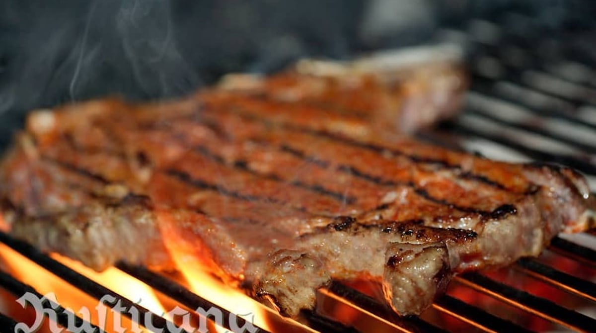 Steak auf dem offenen Holzkohlegrill über der Flamme