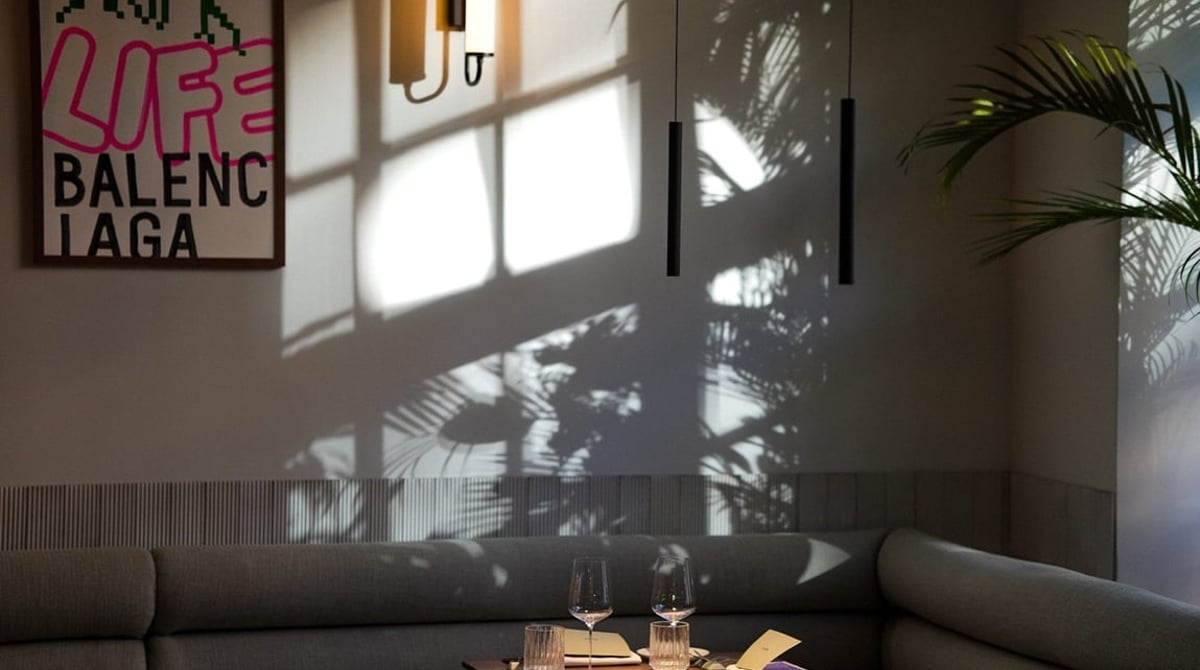 Gastraum des Brothers Restaurant mit Sitzbank, kleinem Tisch und Fenstern, an der Wand ein Poster